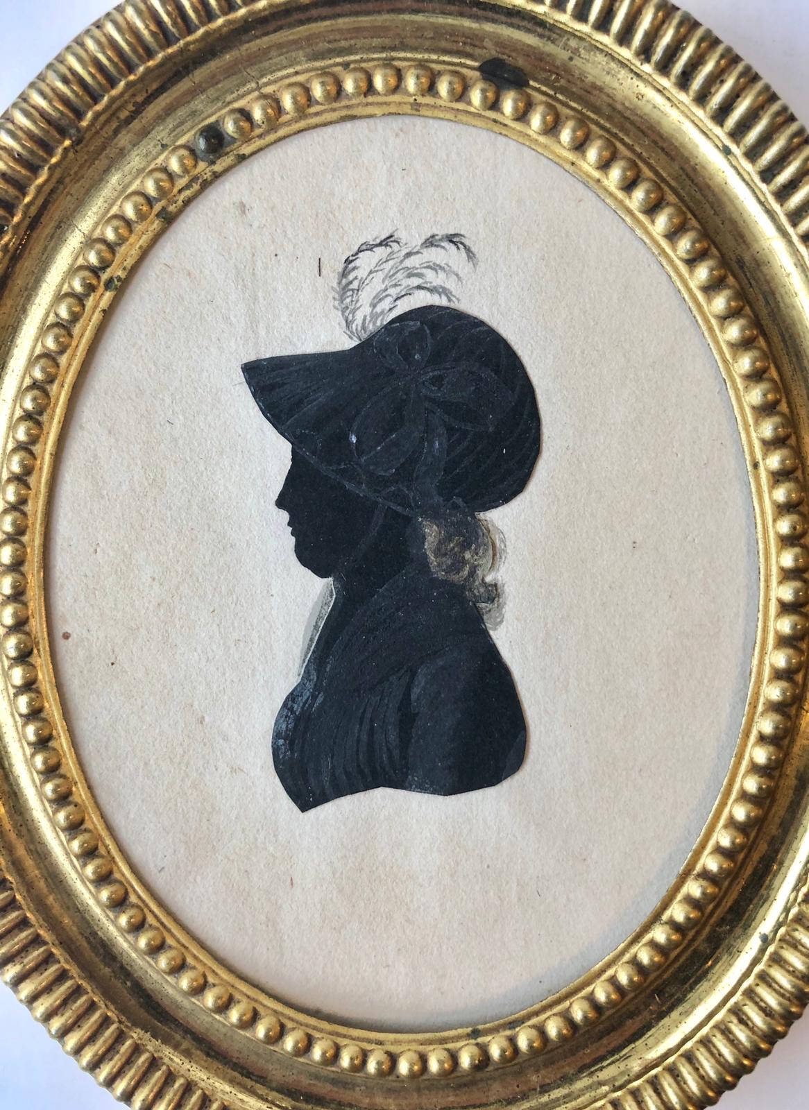 [Silhouette ca 1800] Geknipt en met penseel gehoogd silhouet van een jonge vrouw, ca. 1800, ca. 8 x 5 cm. Verso: R.N(?) van Velsen [waarschijnlijk R.H. van Velsen, wed. E.C.Wiersma , dochter van Mr Abel van Velsen en Sibbeltje Schultz. Zij adverteerde in 1834 te Franeker dat haar moeder was overleden].