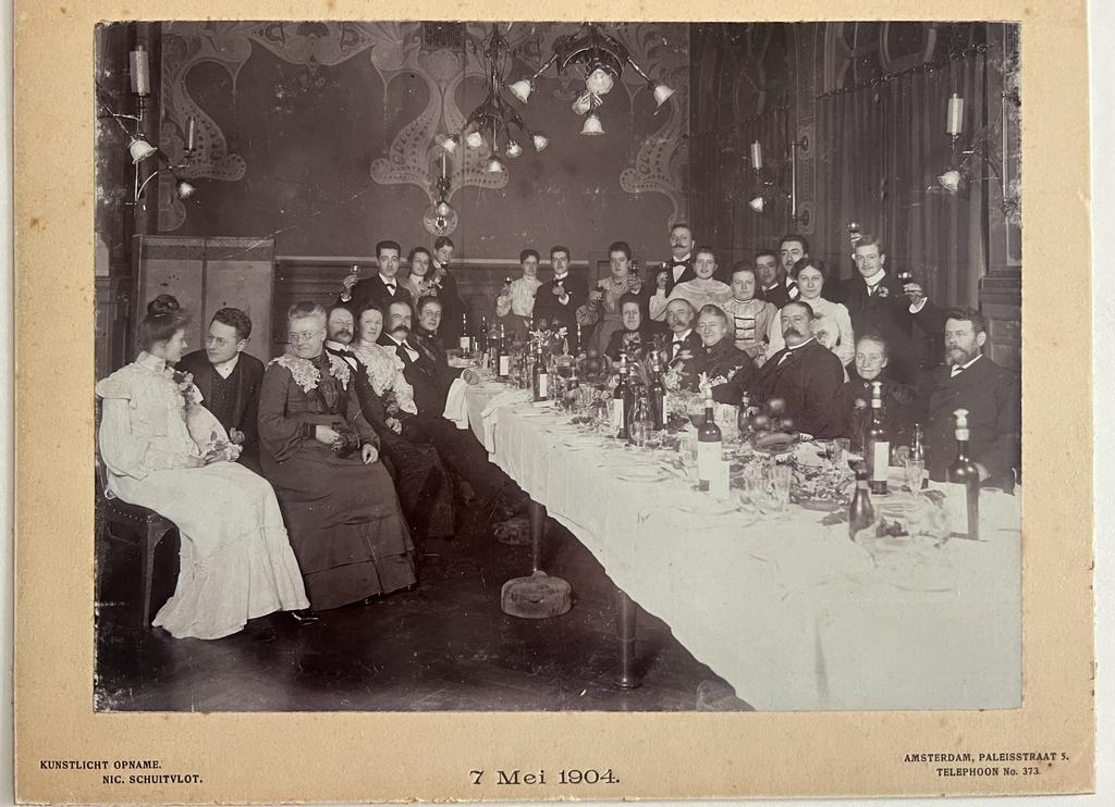 Schuitvlot, Nic., Amsterdam Paleisstraat 5. - Photography 1904 I Photography ca 1904 I Photo of several persons at dinner for the silver marriage of C.O. Roelofs, Amsterdam 7 may 1904, presented by H.L. Kleman Jr to the married couple. Photographer Nico Schuitvlot (Schuytvlot). In jugendstil decor.