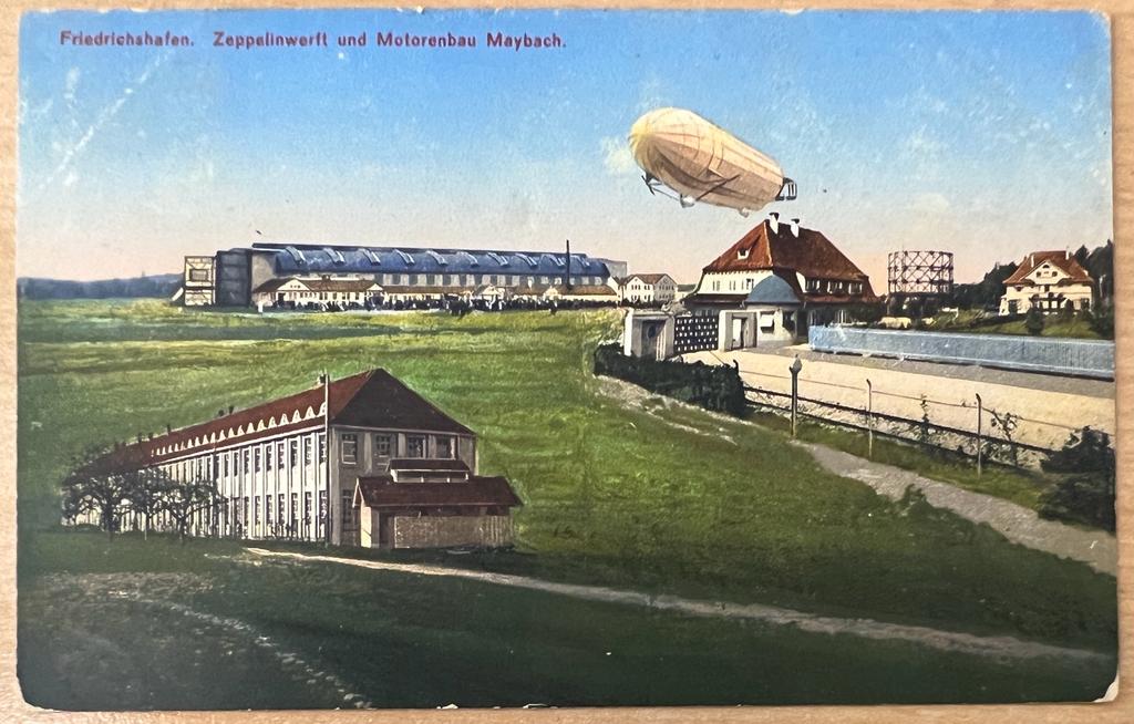 [Zeppelin Postcard] - Aviation, Luchtvaart | Postcard of Zeppelin above Friedrichshafen. Zepplinwerft und Motorenmbau Maybach, coloured, 1 p.