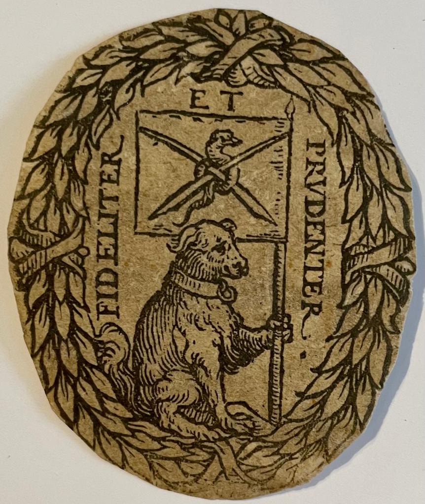  - Printed ornament, date unknown | Gedrukt zegeltje met opdruk 'Fideliter et prudenter' en een hond met banier, 5x4 cm.